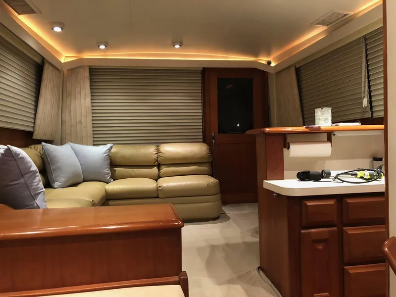 Slide: The Image of Interior of 1990 Viking 38 Convertible yacht with leather seating and wooden cabinetry. - 10