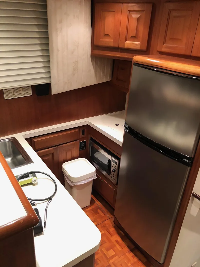 Slide: The Image of 1990 Viking 38 Convertible yacht kitchen with wood cabinets and stainless steel appliances. - 11