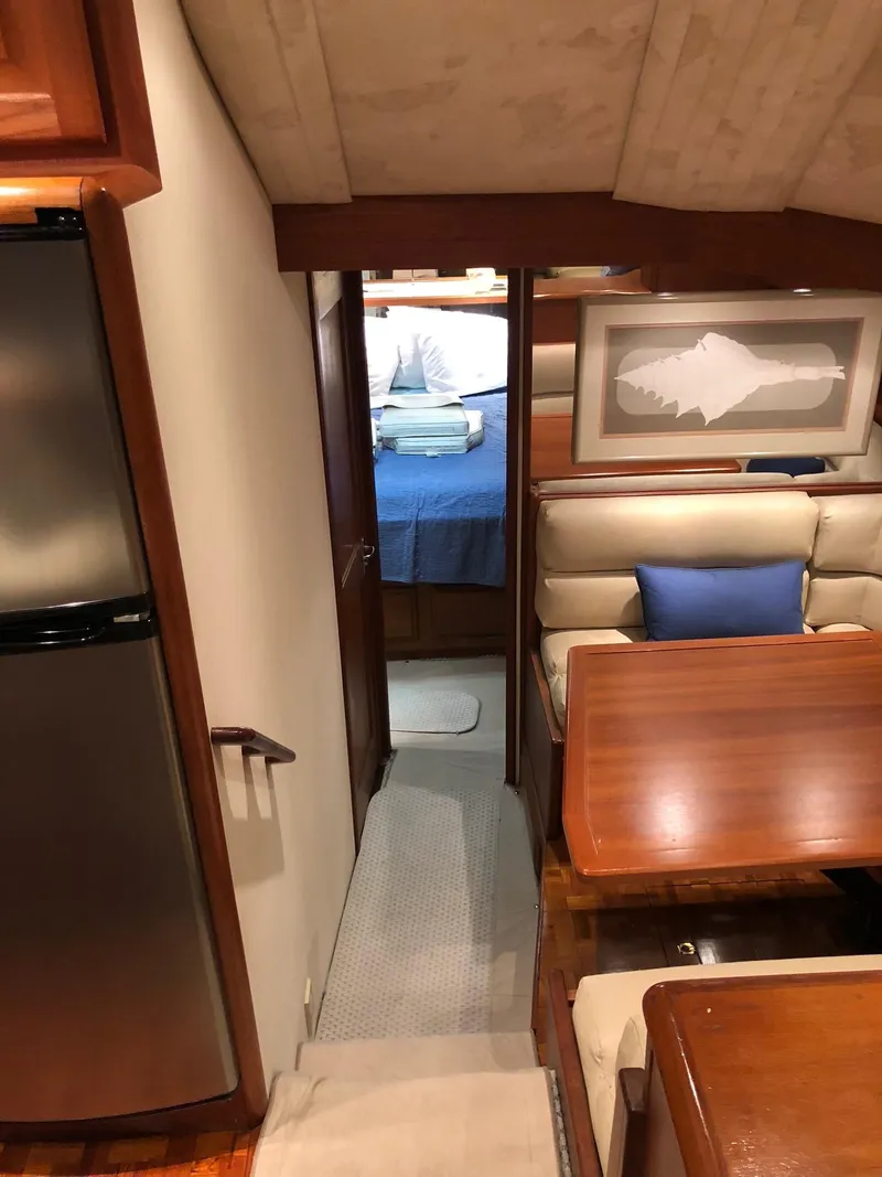Slide: The Image of Interior of a 1990 Viking 38 Convertible yacht with dining area and bedroom. - 13