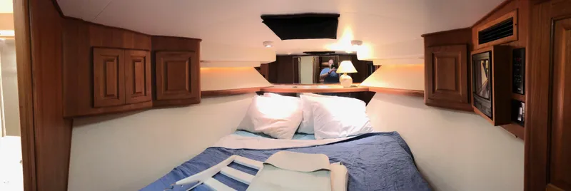 Slide: The Image of Cozy cabin interior of 1990 Viking 38 Convertible yacht with wooden cabinets and bedding. - 20