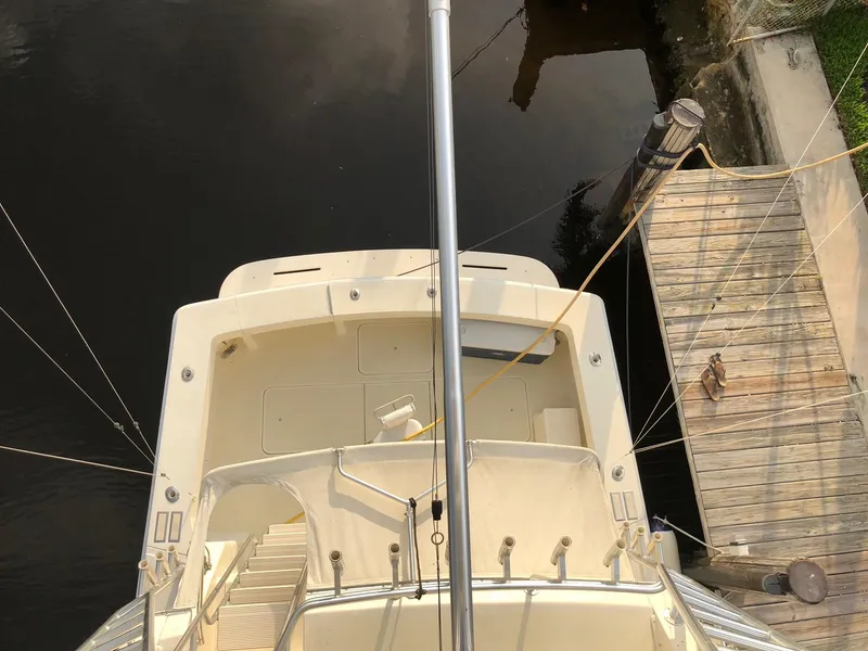 Slide: The Image of Overhead view of a 1990 Viking 38 Convertible yacht docked by a wooden pier. - 23