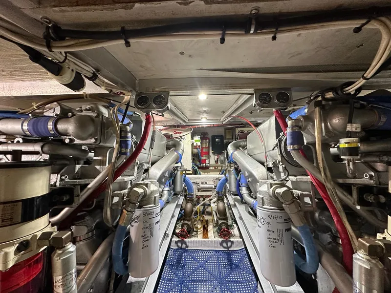 Slide: The Image of Engine room of 1990 Viking 38 Convertible boat, showcasing complex machinery and piping. - 24