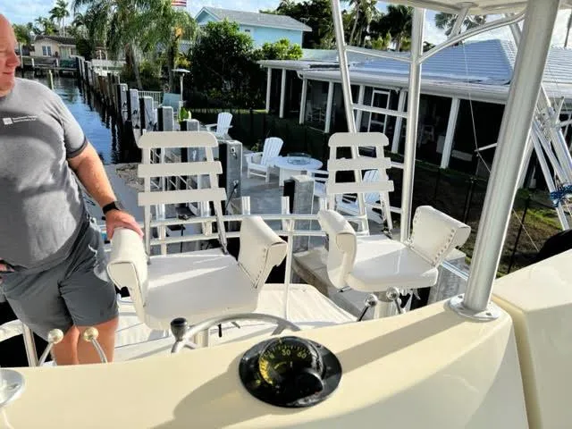 Slide: The Image of Man on 1990 Viking 38 Convertible yacht with white chairs and compass, dockside view. - 3