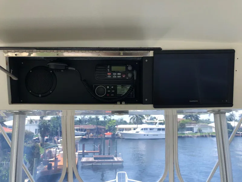 Slide: The Image of 1990 Viking 38 Convertible boat dashboard with radio and display screen, overlooking marina. - 4