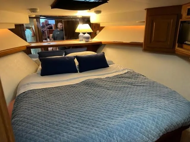 Slide: The Image of Cozy bedroom in 1990 Viking 38 Convertible yacht with blue bedding and wooden accents. - 6
