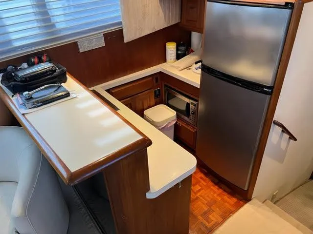Slide: The Image of 1990 Viking 38 Convertible yacht kitchen with modern appliances and wooden cabinetry. - 8