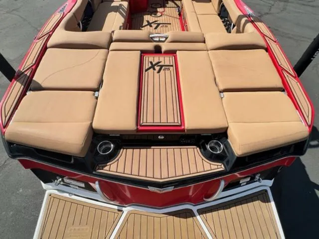 Slide: The Image of 2019 MasterCraft XT25 boat with tan seats and red accents. - 10