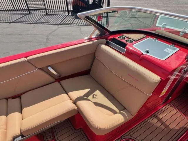 Slide: The Image of 2019 MasterCraft XT25 boat interior with tan seats and red accents. - 14