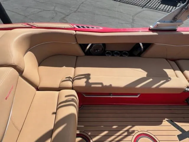 Slide: The Image of 2019 MasterCraft XT25 boat interior with tan seating and red accents. - 15