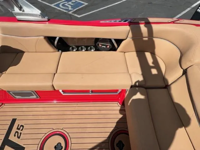 Slide: The Image of 2019 MasterCraft XT25 boat interior with beige seating and red accents. - 17