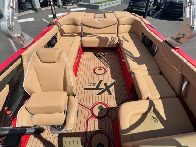 Slide: The Image of 2019 MasterCraft XT25 boat interior with tan seating and red accents. - 19