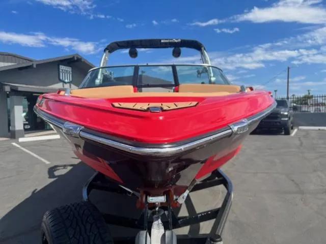 Slide: The Image of 2019 MasterCraft XT25 boat with red hull on trailer, parked outdoors. - 3