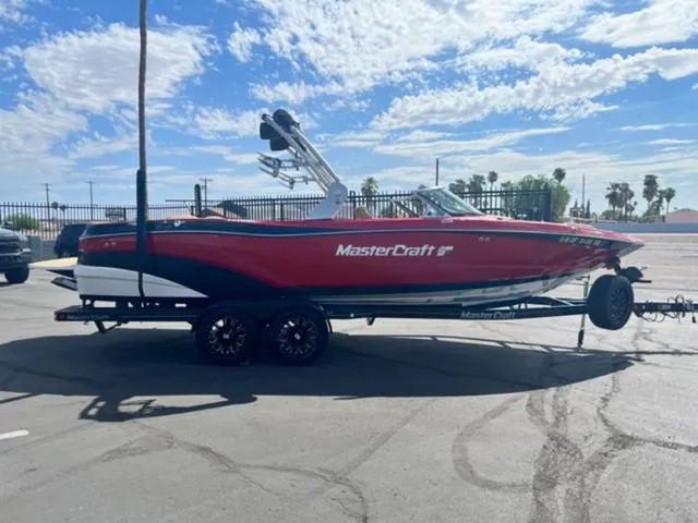 Slide: The Image of 2019 MasterCraft XT25 boat on a trailer under a clear blue sky. - 5