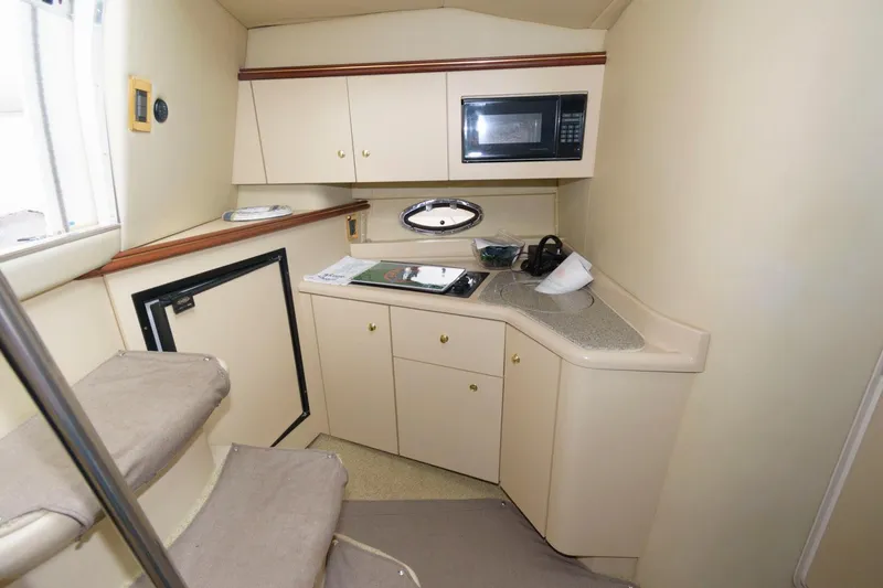 Slide: The Image of 2002 Cruisers Yachts 3372 Express cabin kitchen with microwave, cabinets, and countertop. - 19