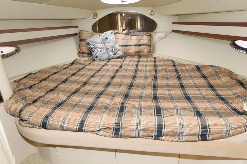 Slide: The Image of 2002 Cruisers Yachts 3372 Express cabin with plaid bedding and decorative pillows. - 20