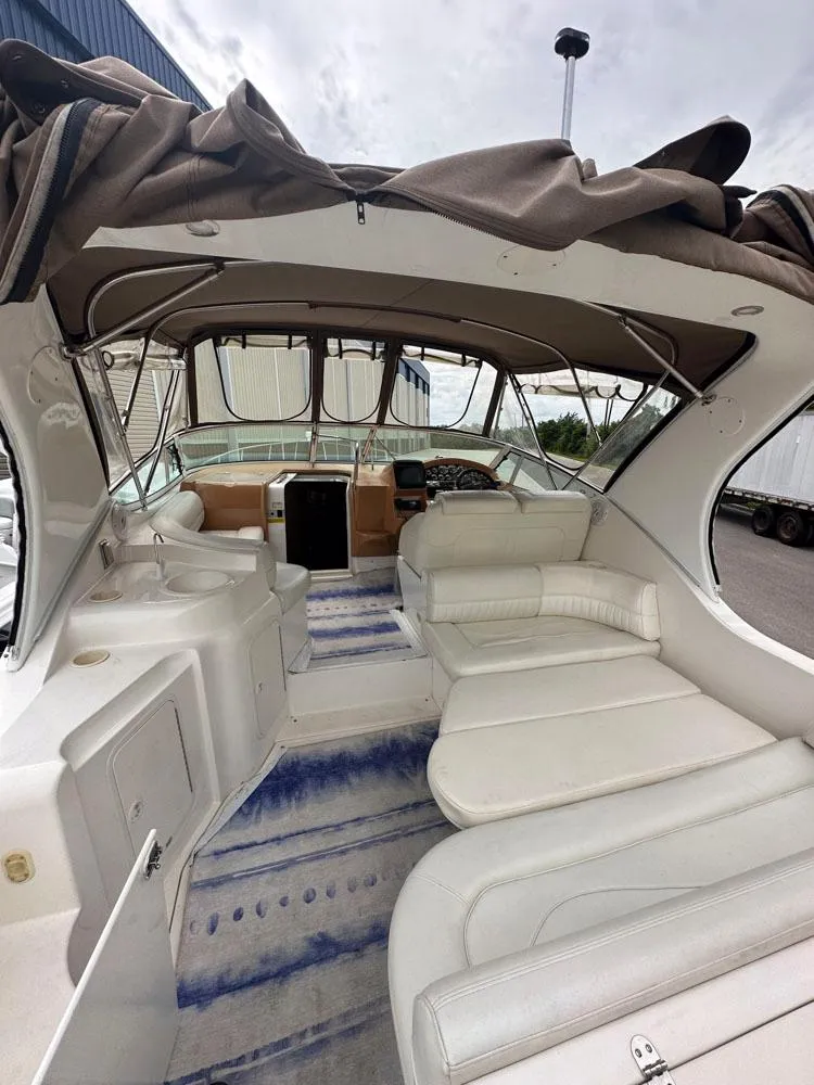 Slide: The Image of 2002 Cruisers Yachts 3372 Express interior with white seating and helm station. - 14