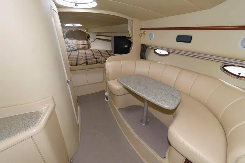Slide: The Image of Interior of 2002 Cruisers Yachts 3372 Express with beige seating and sleeping area. - 17