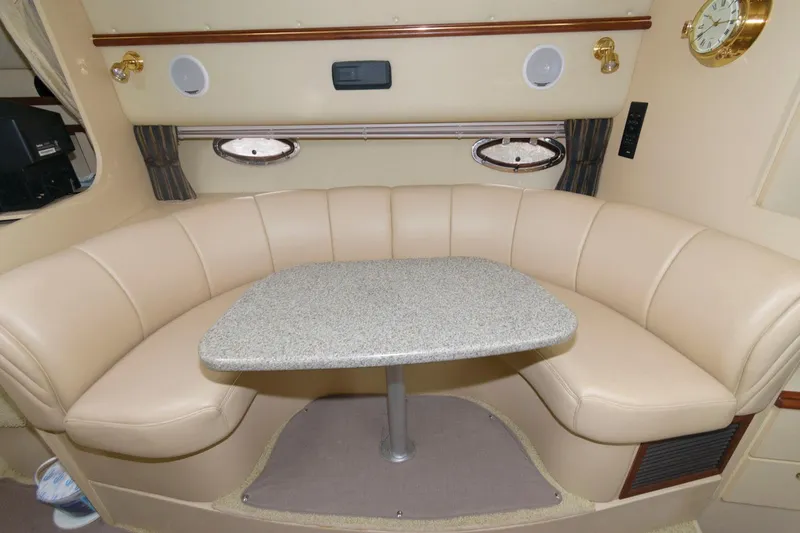 Slide: The Image of 2002 Cruisers Yachts 3372 Express interior dining area with beige leather seating and table. - 18