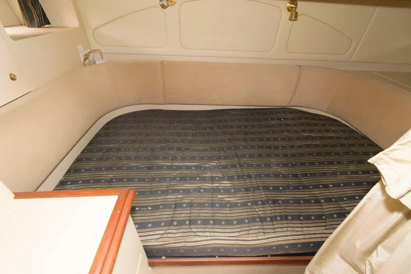 Slide: The Image of 2002 Cruisers Yachts 3372 Express cabin bed with striped bedding. - 21