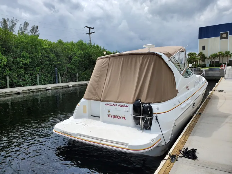 Slide: The Image of 2002 Cruisers Yachts 3372 Express docked at marina with tan cover. - 3