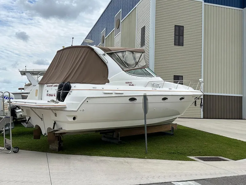 Slide: The Image of 2002 Cruisers Yachts 3372 Express boat on dry dock near a storage facility. - 4