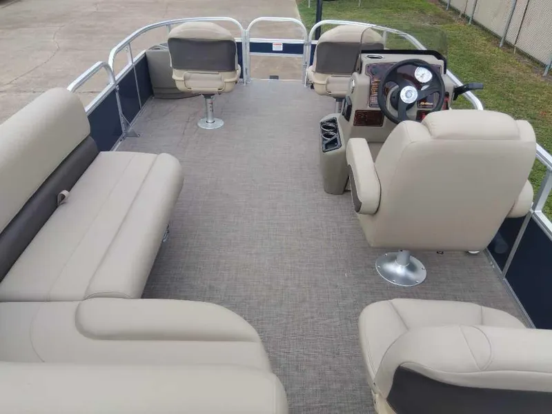 Slide: The Image of 2024 Sun Tracker Bass Buggy 18 DLX pontoon boat interior with beige seating. - 2
