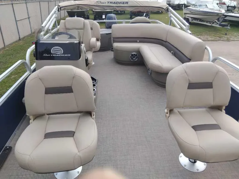 Slide: The Image of 2024 Sun Tracker Bass Buggy 18 DLX pontoon boat with beige seating and spacious deck. - 4