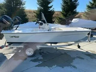 The Image of 2024 Mako Pro Skiff 13 CC boat on trailer, outdoors with trees in background. - 0