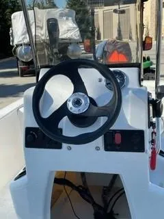 Slide: The Image of 2024 Mako Pro Skiff 13 CC boat console with steering wheel and controls. - 1