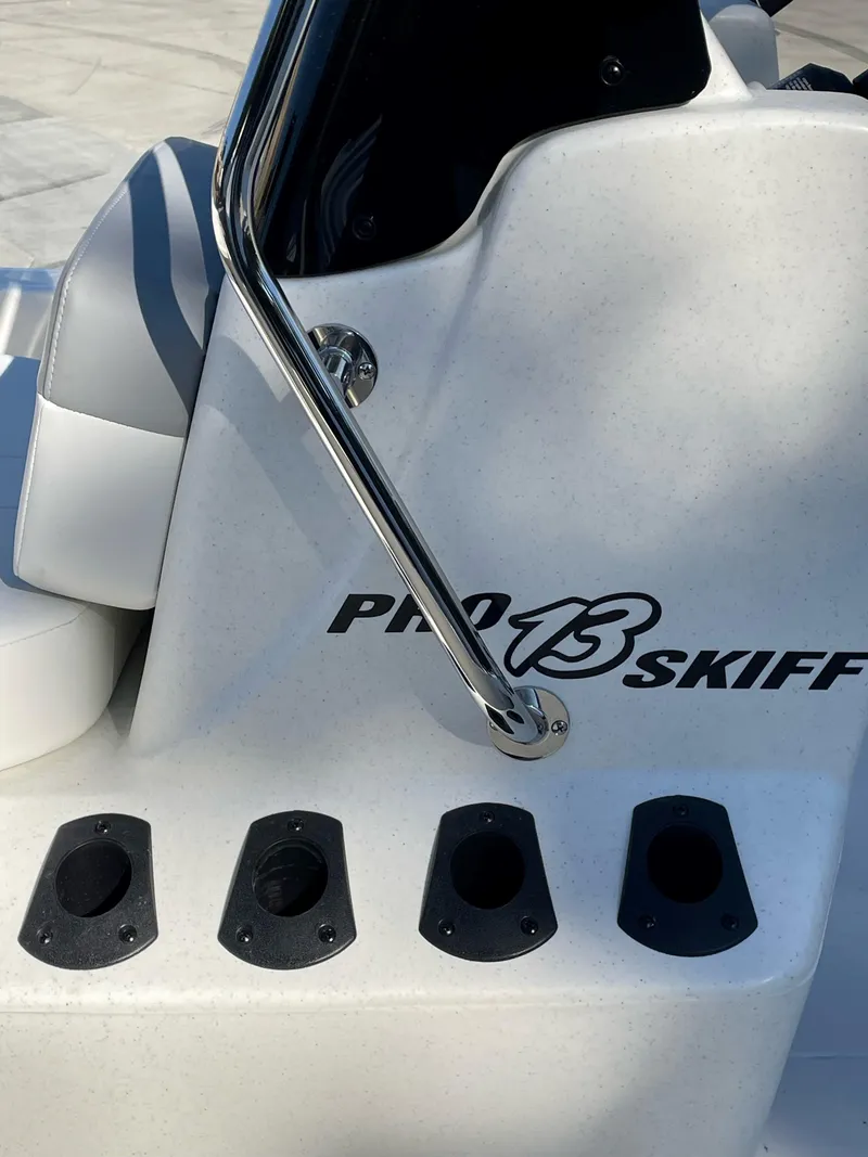 Slide: The Image of 2024 Mako Pro Skiff 13 CC boat console with rod holders and sleek design. - 4