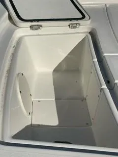 Slide: The Image of 2024 Mako Pro Skiff 13 CC storage compartment, open lid, white interior. - 5