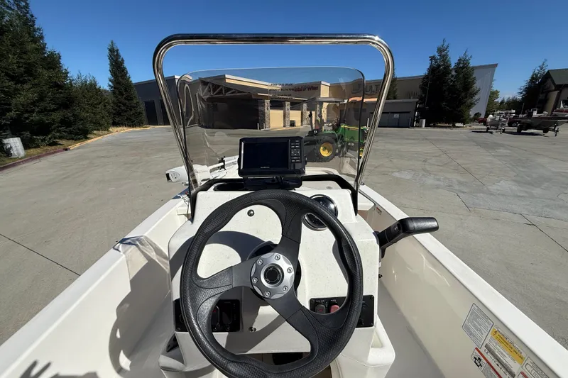 Slide: The Image of 2024 Mako Pro Skiff 13 CC boat dashboard with steering wheel and navigation system. - 12
