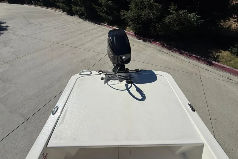 Slide: The Image of 2024 Mako Pro Skiff 13 CC boat with outboard motor on a concrete surface. - 7
