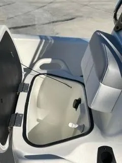 Slide: The Image of 2024 Mako Pro Skiff 13 CC boat storage compartment with open lid and seat. - 7