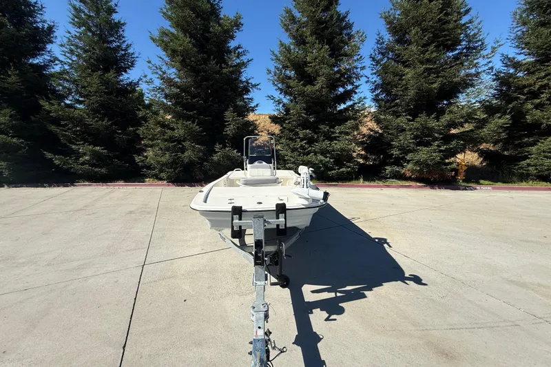 Slide: The Image of 2024 Mako Pro Skiff 13 CC boat on trailer, surrounded by tall trees. - 4