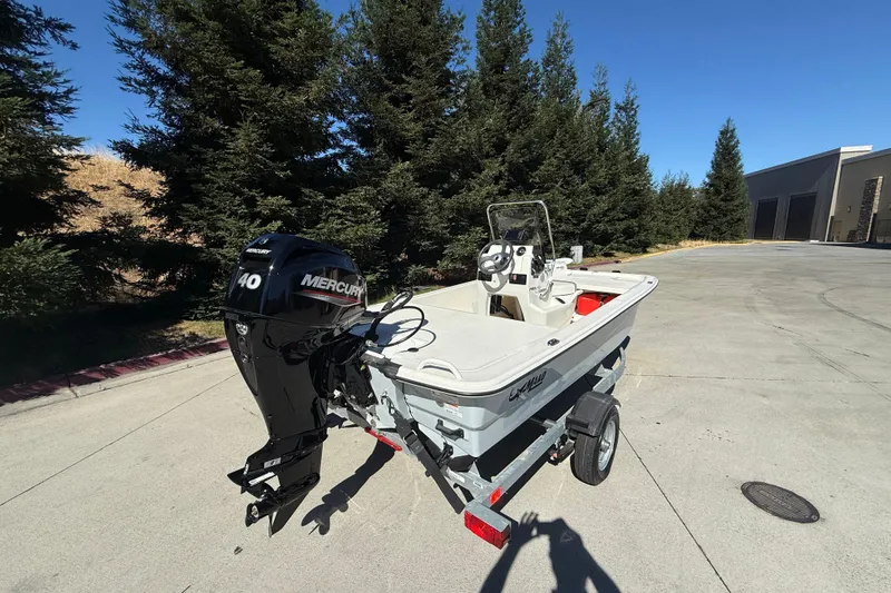 Slide: The Image of 2024 Mako Pro Skiff 13 CC boat with Mercury 40 engine on trailer, outdoors. - 3