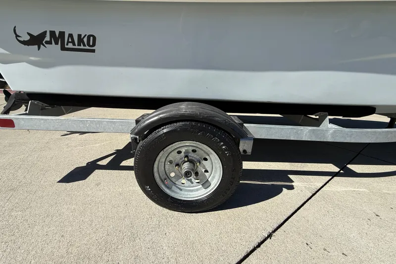 Slide: The Image of Trailer wheel of 2024 Mako Pro Skiff 13 CC boat on concrete surface. - 19
