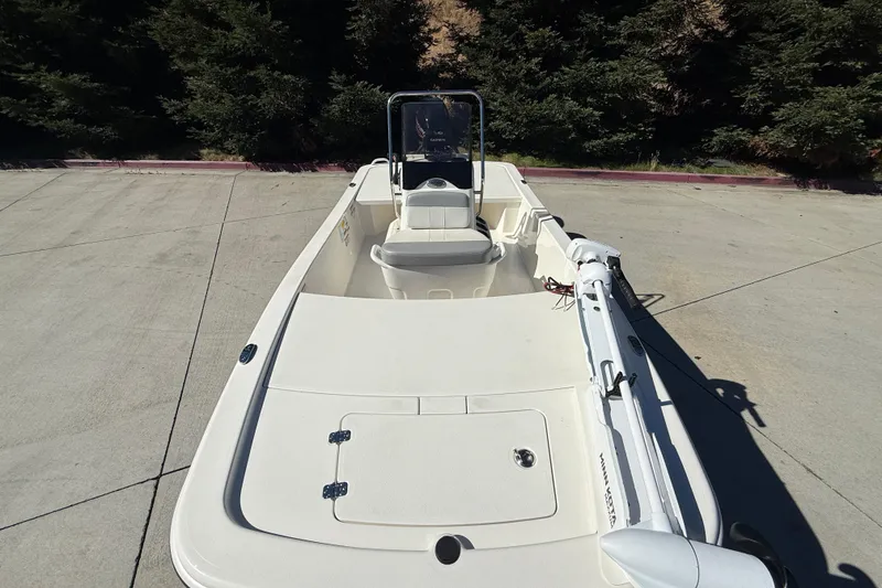 Slide: The Image of 2024 Mako Pro Skiff 13 CC boat on concrete, featuring a sleek design and spacious deck. - 8