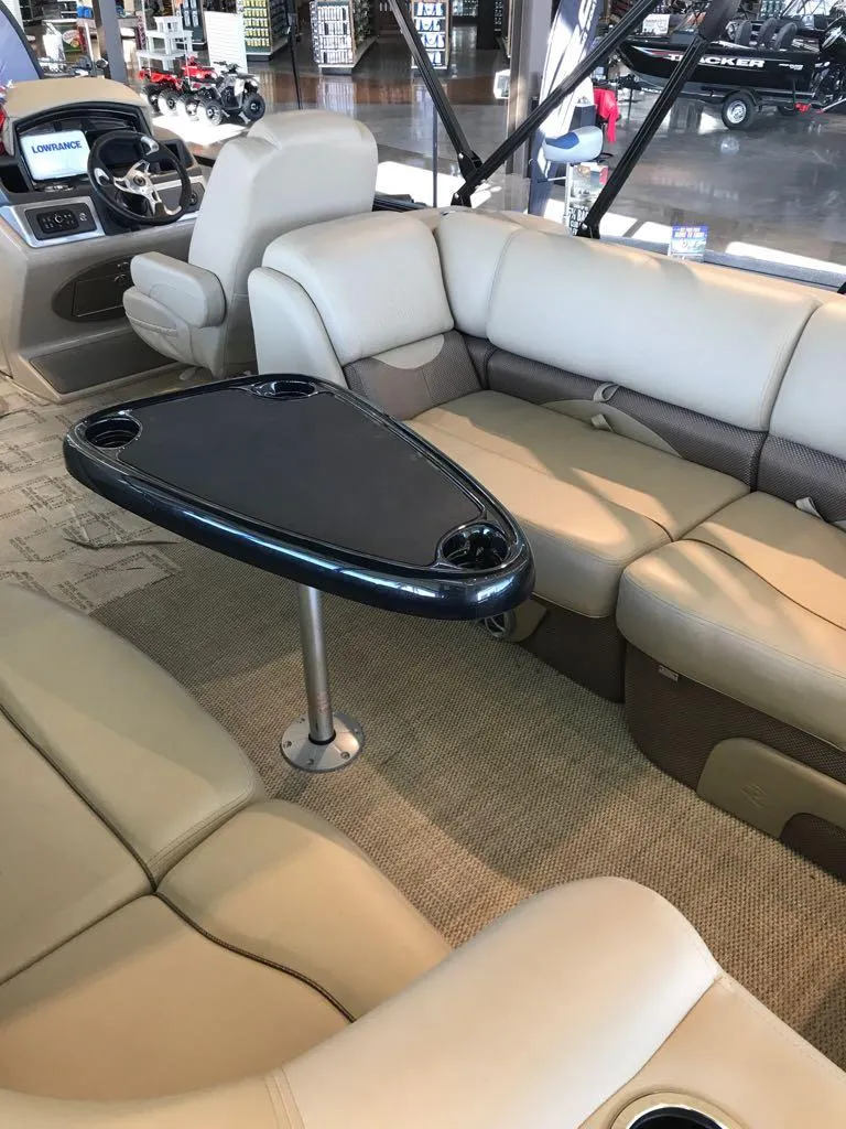 Slide: The Image of 2024 Regency 230 DL3 boat interior with plush seating and sleek table design. - 10