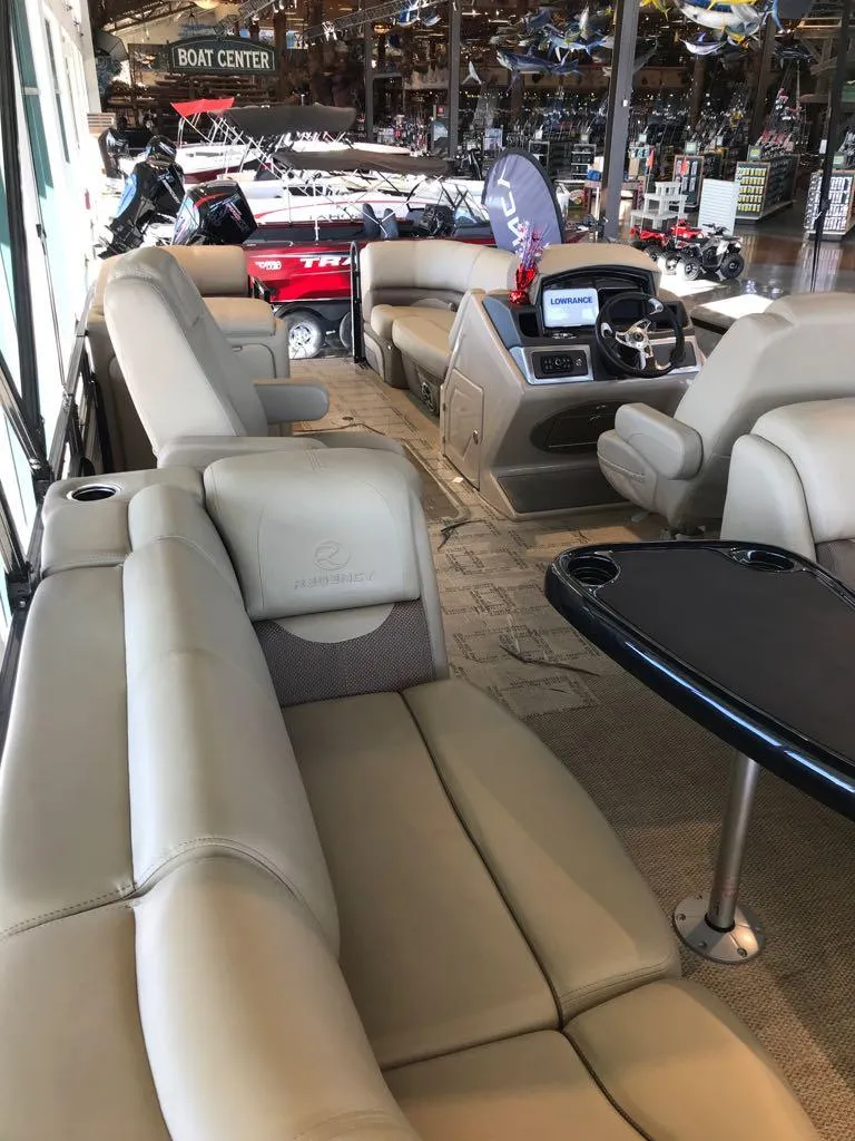 Slide: The Image of 2024 Regency 230 DL3 pontoon boat interior with luxurious seating and modern dashboard. - 13