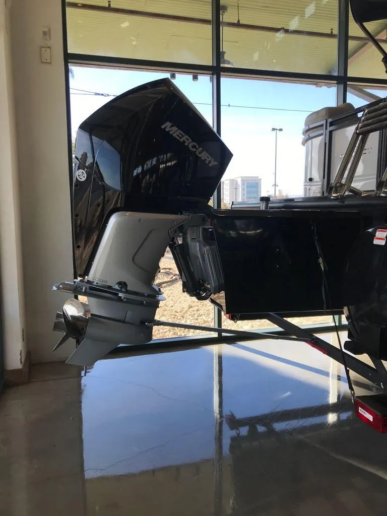 Slide: The Image of 2024 Regency 230 DL3 boat with Mercury outboard motor in showroom. - 6