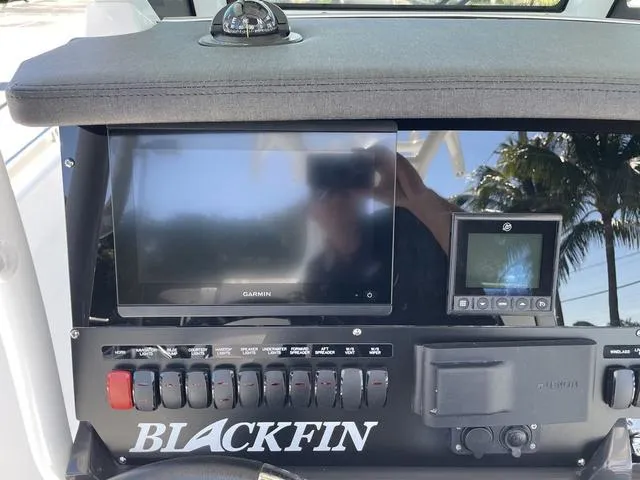 Slide: The Image of 2023 Blackfin 272CC boat dashboard with Garmin display and control switches. - 11
