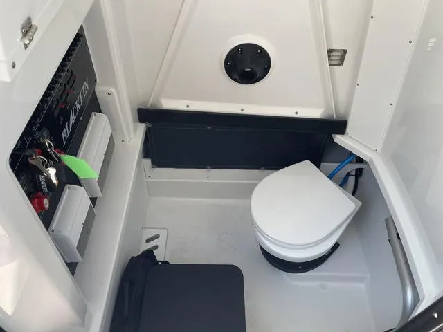 Slide: The Image of 2023 Blackfin 272CC boat interior with marine toilet and control panel. - 25