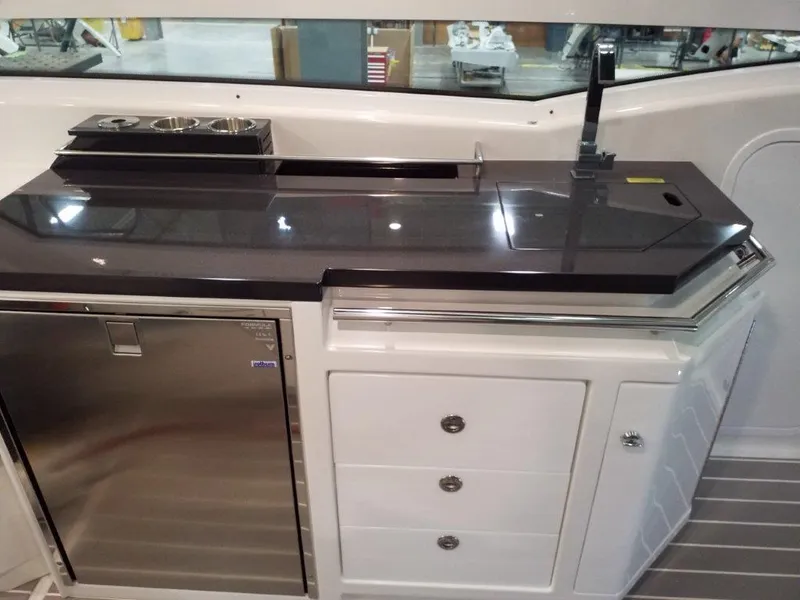 Slide: The Image of 2020 Formula 430 All Sport Crossover yacht kitchen with stainless steel fridge and black countertop. - 26