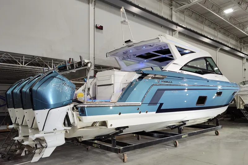 Slide: The Image of 2020 Formula 430 All Sport Crossover boat with multiple outboard engines in a showroom. - 3