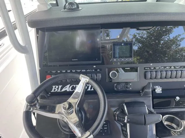 Slide: The Image of 2023 Blackfin 272CC boat dashboard with steering wheel, navigation screens, and control panel. - 11