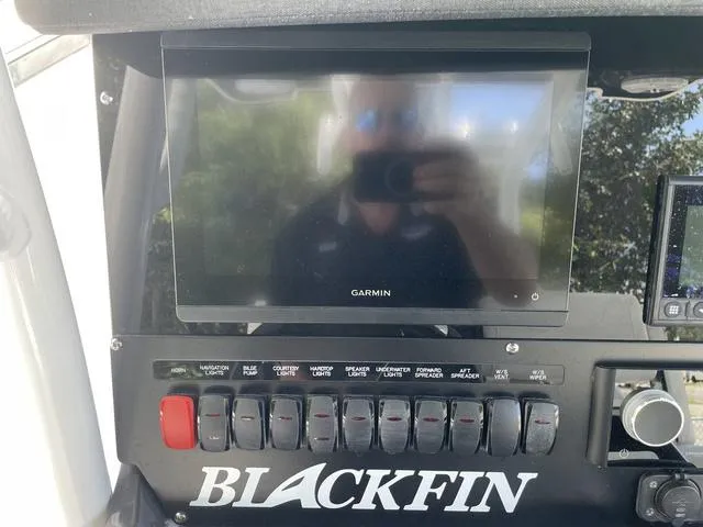 Slide: The Image of 2023 Blackfin 272CC boat dashboard with Garmin display and control switches. - 13