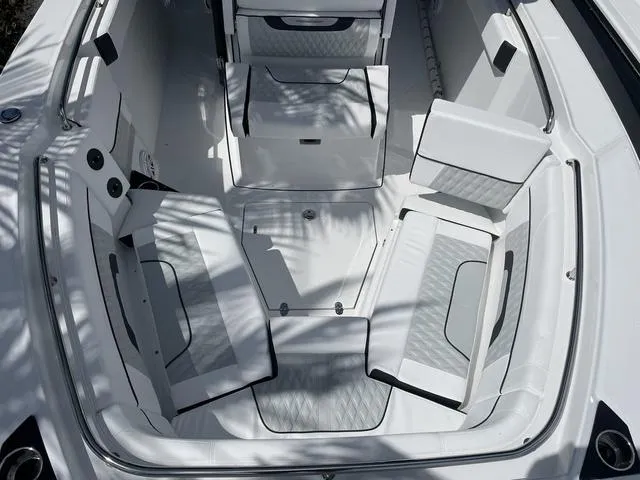 Slide: The Image of 2023 Blackfin 272CC boat interior with white cushioned seating and storage compartments. - 23