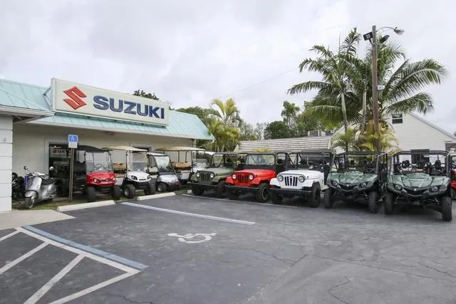 Slide: The Image of Suzuki dealership with various off-road vehicles parked outside. - 41