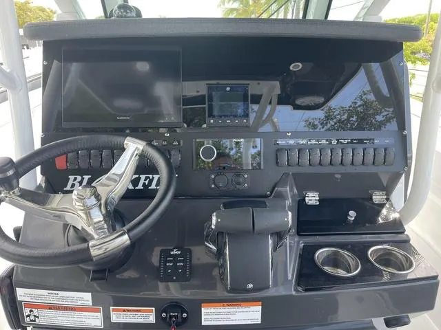Slide: The Image of 2023 Blackfin 272CC boat dashboard with steering wheel, navigation screens, and control panel. - 9